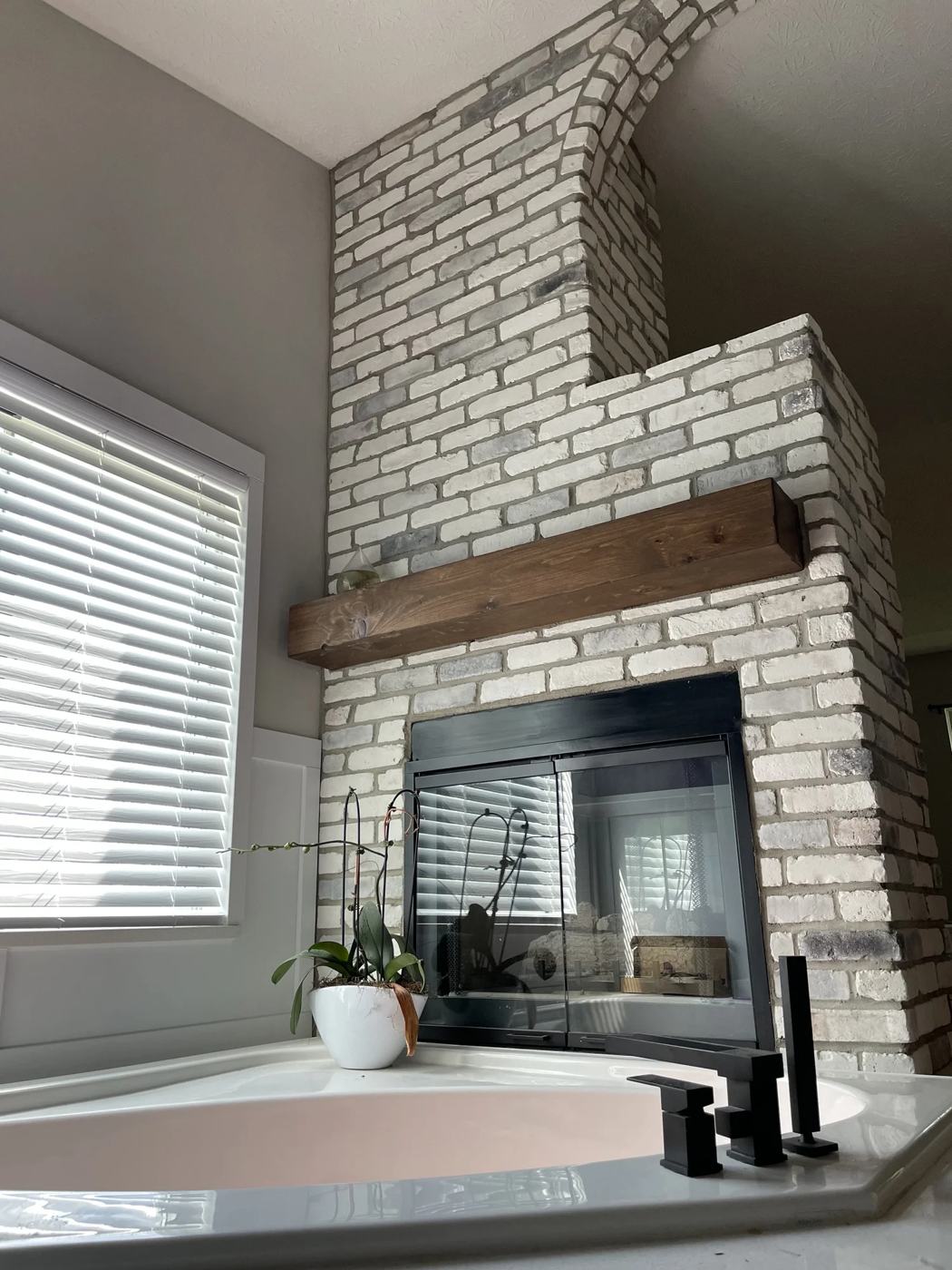 Stone fireplace beside a soaking tub