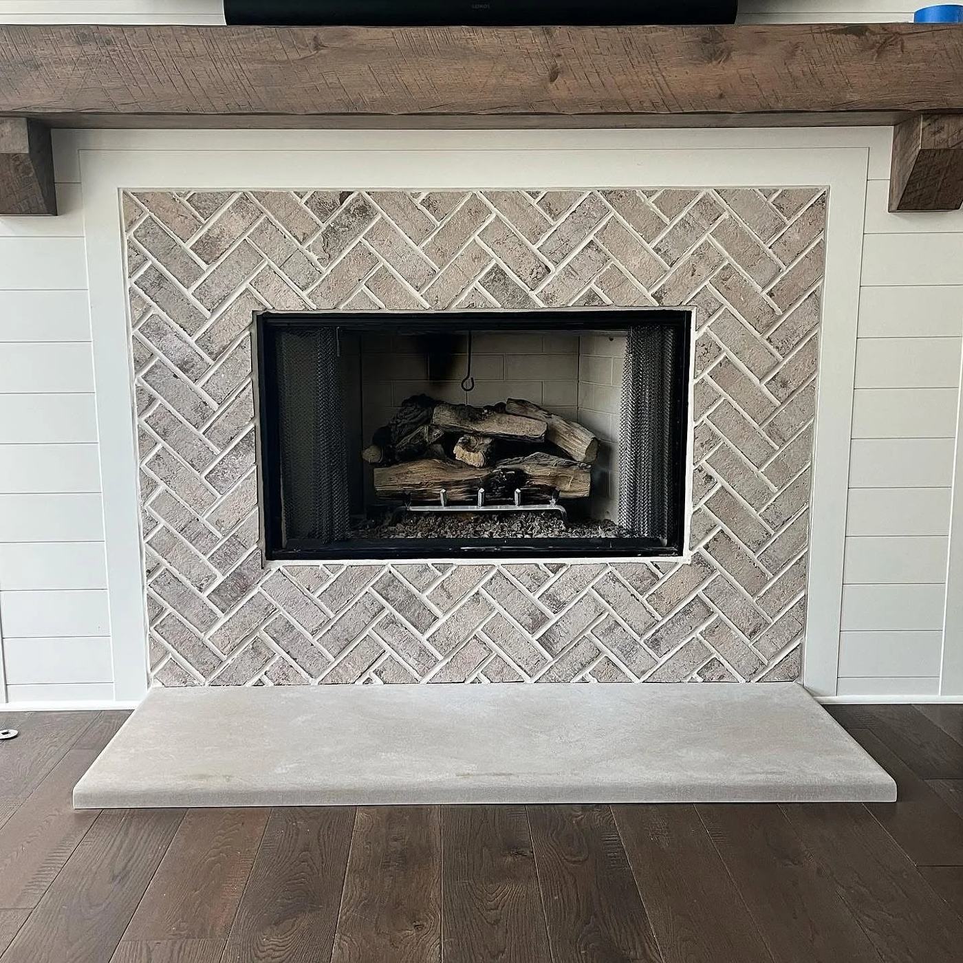 Herringbone tile fireplace with a timber mantel