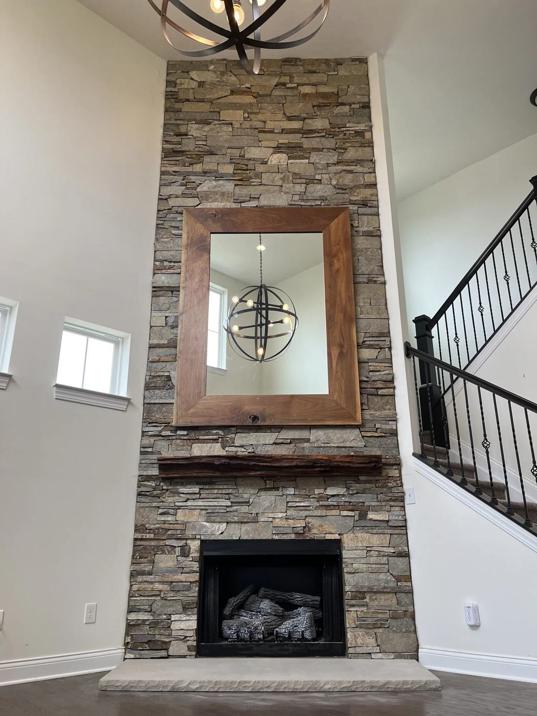 Stone fireplace with reclaimed timber mantel and mirror