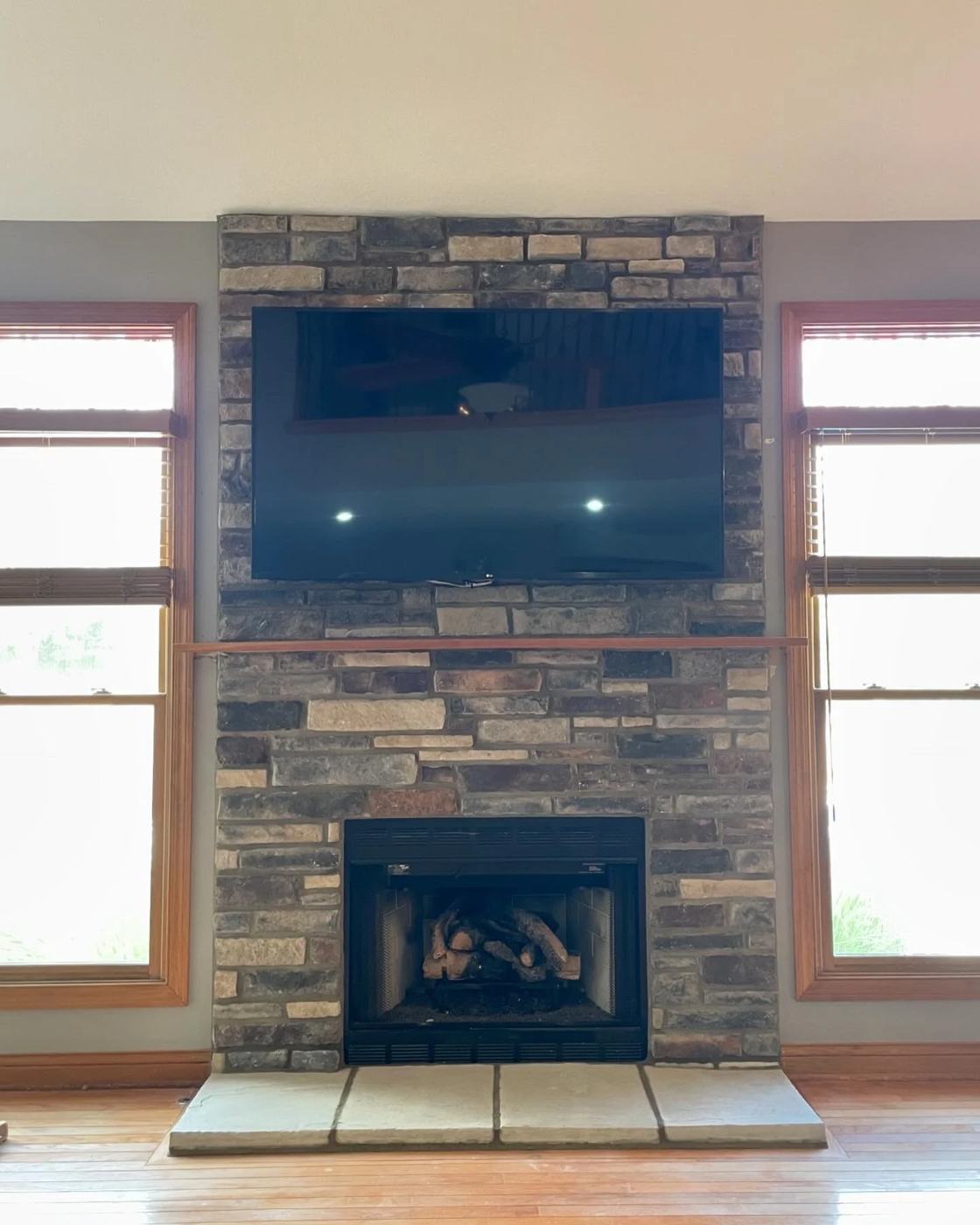 Stone fireplace with a mounted television above